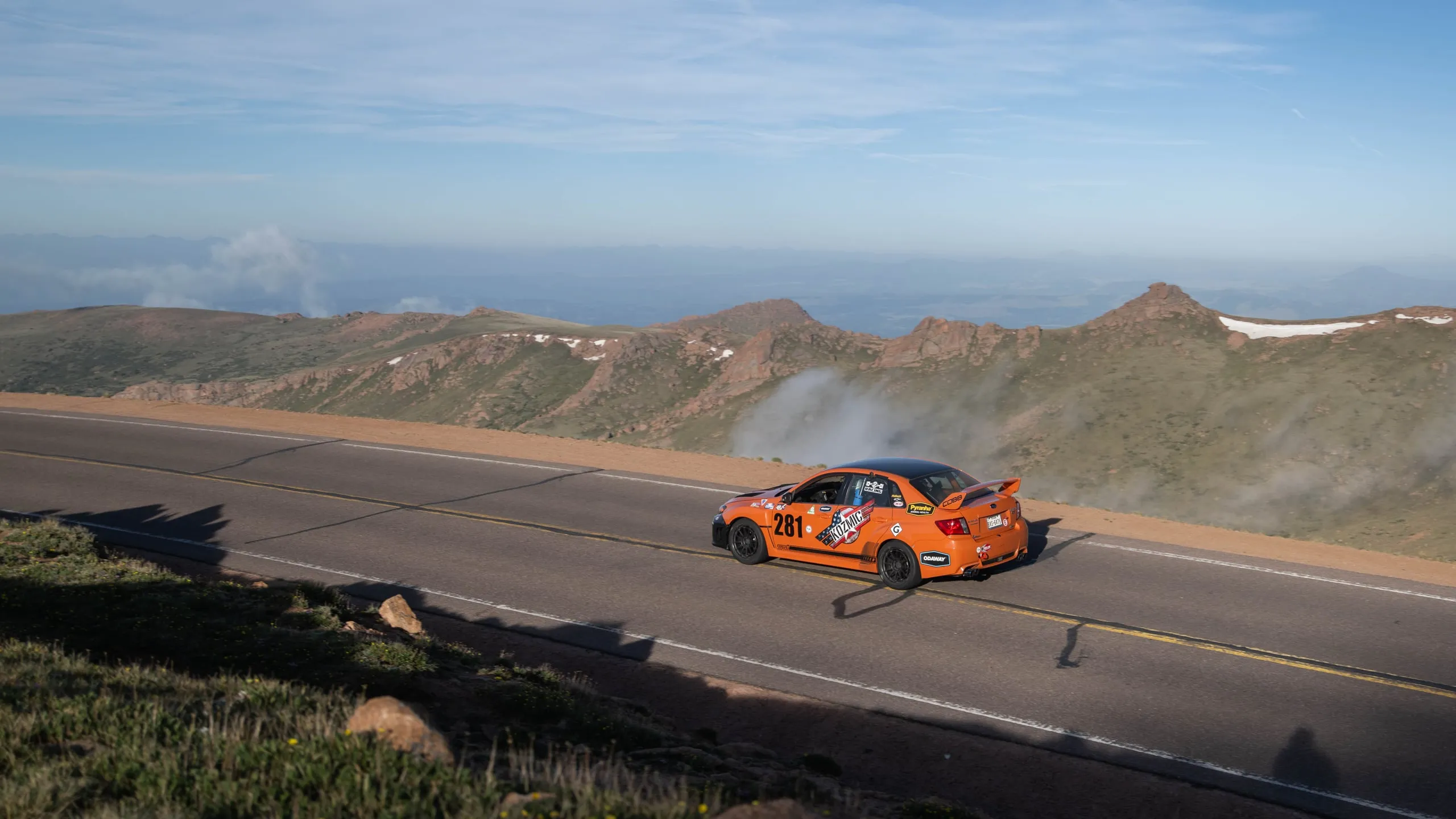 The #281 Subaru WRX STI on the summit ridge, clouds below, at Pikes Peak 2026